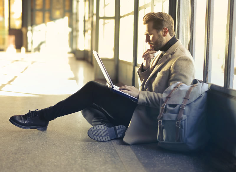 Business man sitting on the floor with a laptop