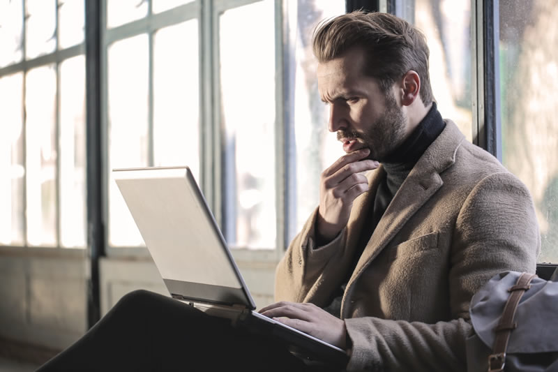 Man sitting in business setting with a laptop