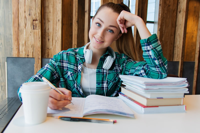 Female student doing homework with a smile