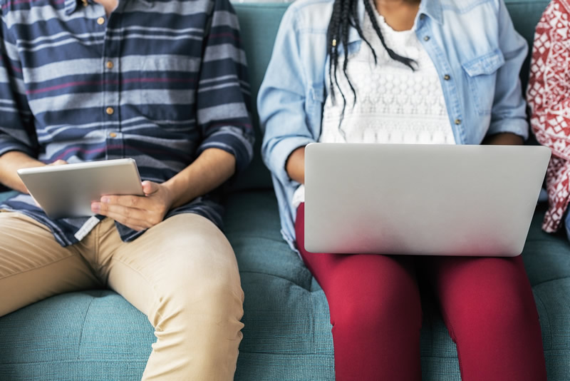 Two students sitting together with laptops