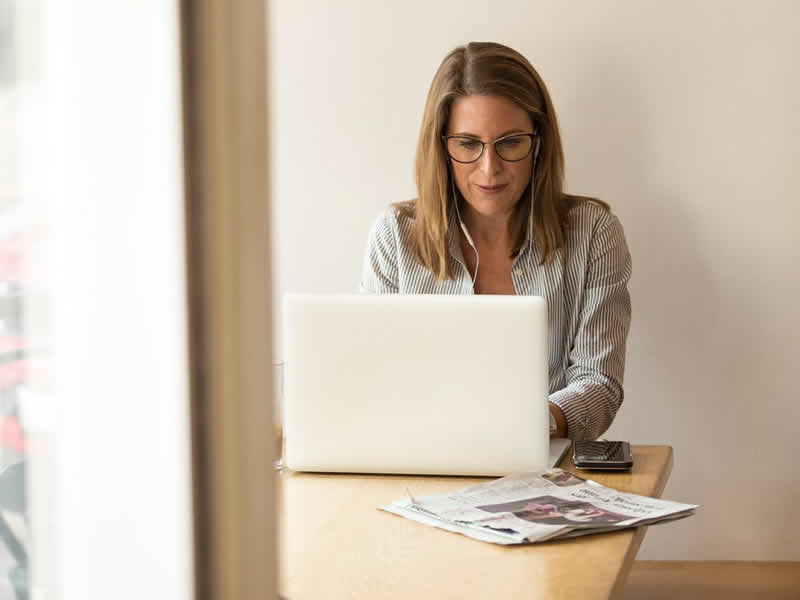 Woman at kitchen table with laptop